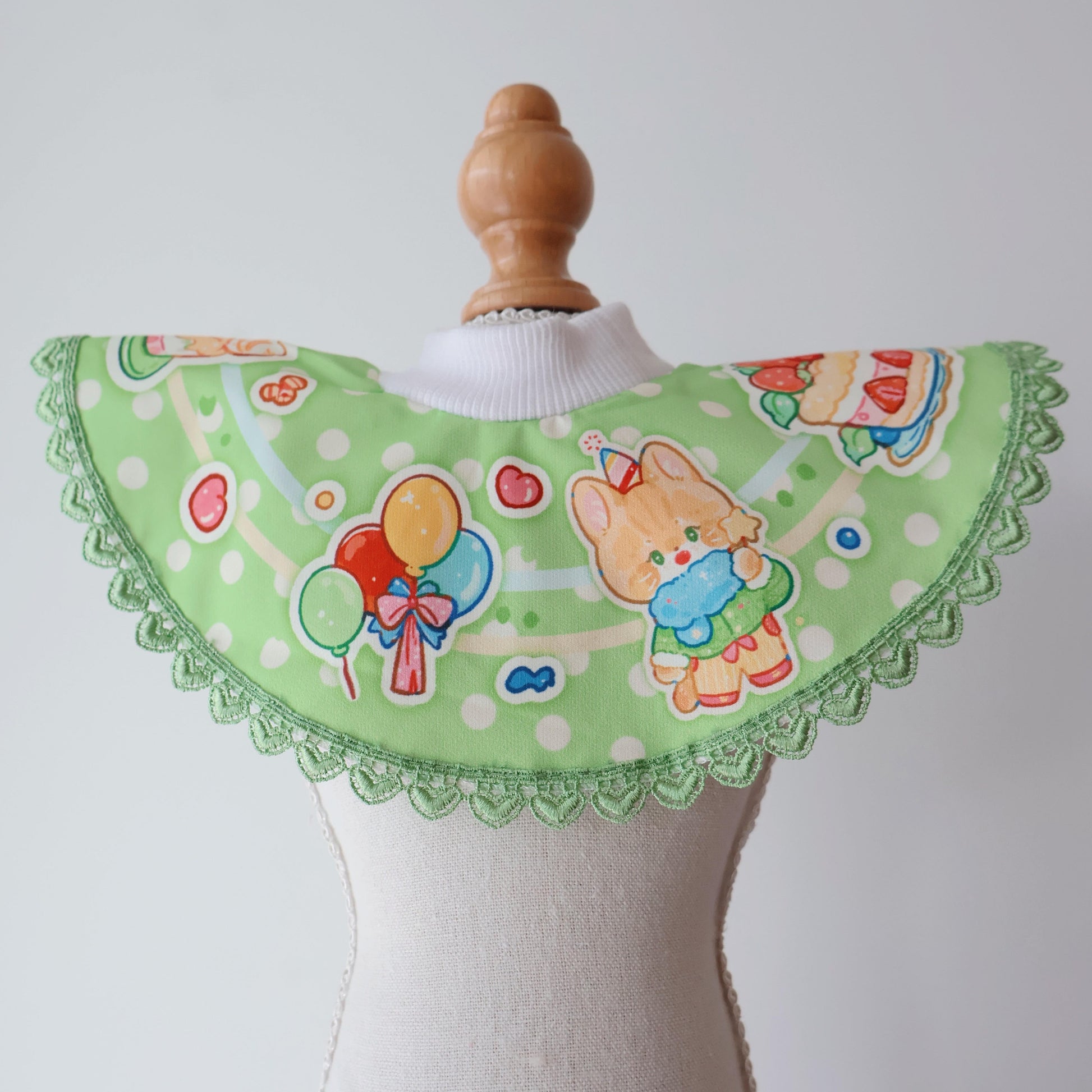 This photo showcases our size small birthday collection pet bib in green on the mannequin, recommended specifically for kittens and puppies.